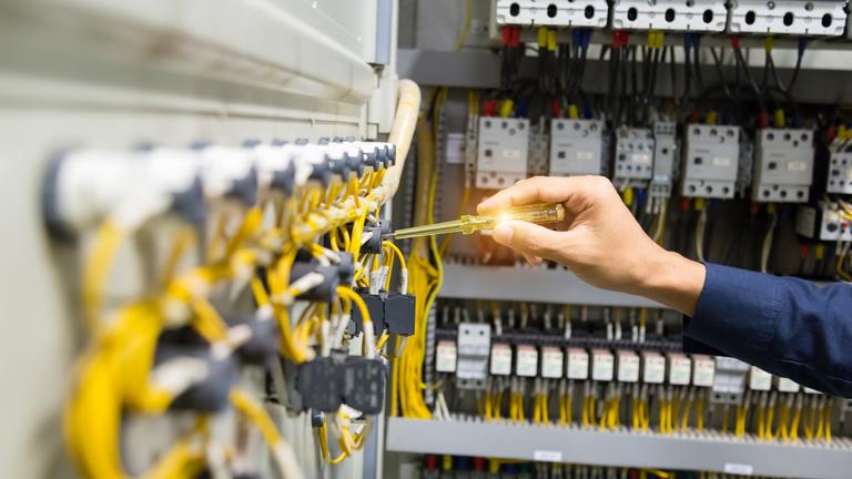 electricians-hands-testing-current-electric-control-panel